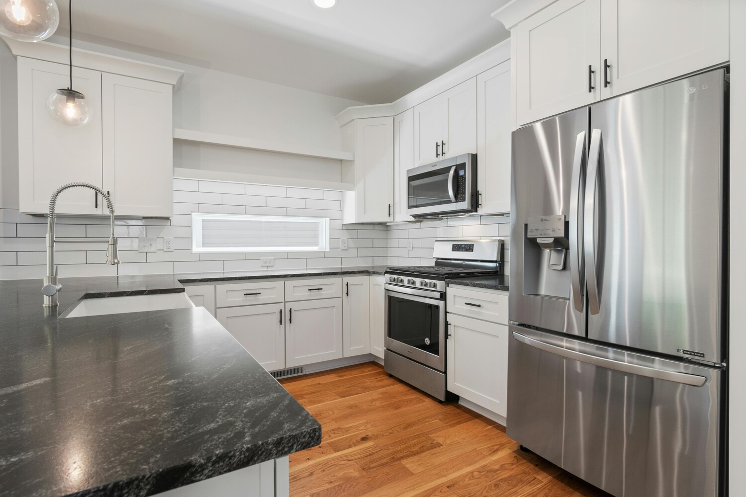 Sleek kitchen remodel with black countertops and subway tile by SmartSpaces ADUs in Tucker, GA