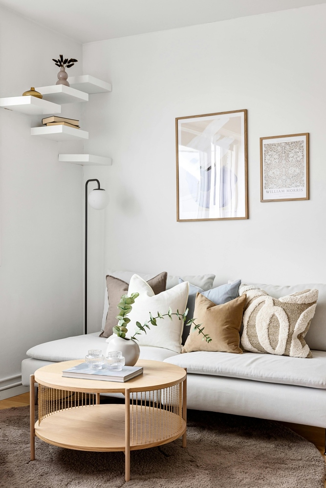Minimalist living room with neutral pillows and round wood coffee table in a Smart Spaces ADUs custom home in Eastern Atlanta, GA - stock Minimalist living room with neutral pillows and round wood coffee table in a Smart Spaces ADUs custom home in Eastern Atlanta, GA - stock