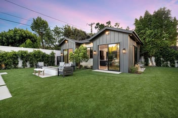 Image of a two-bedroom accessory dwelling unit in the backyard of an Atlanta home, equipped with sliding glass doors, accent lighting, a firepit, and a garden area.