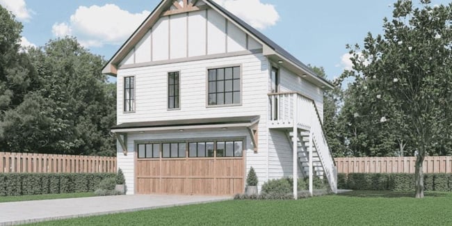 Rendering of a two-story SmartSpaces ADU above a detached garage with white siding, wood garage doors, and an exterior staircase.